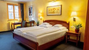 a bedroom with a large bed and a desk at Altstadthotel Bräuwirt in Weiden +75 photos
