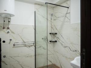 a bathroom with a shower with a glass door at Megdan prenočište in Požarevac