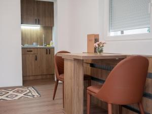 a kitchen with a wooden table and chairs at Megdan prenočište in Požarevac