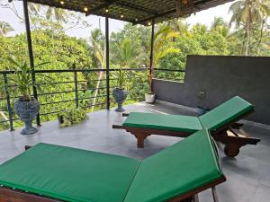 a patio with a green couch and a table at Fair view in Induruwa