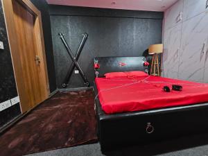 a bedroom with a black bed with a red blanket at The Secret Escape in Bahādurgarh