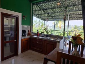 a kitchen with a table and a large window at Fair view in Induruwa