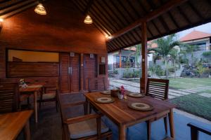 an outdoor dining room with a wooden table and chairs at Gistari Inn & Restaurant in Seraya