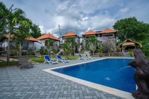 a swimming pool in front of a house at Gistari Inn & Restaurant in Seraya