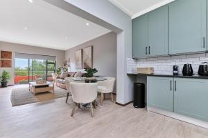 a kitchen and living room with a table and chairs at Afrikaya Luxurious Apartment in Roodepoort