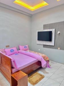 a bedroom with a bed and a flat screen tv at Mbogo Safari Hotel in Karatu +19 photos