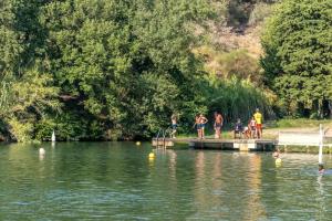 a group of people standing on a dock on a lake at ZEcamping 3 étoiles animaux acceptés en bord de lac in Vinça