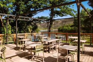 a bunch of tables and chairs on a deck at ZEcamping 3 étoiles animaux acceptés en bord de lac in Vinça