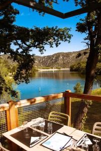 a table on a deck with a view of a lake at ZEcamping 3 étoiles animaux acceptés en bord de lac in Vinça