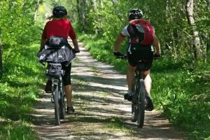 two people riding bikes down a dirt trail at ZEcamping 3 étoiles animaux acceptés en bord de lac in Vinça +17 photos