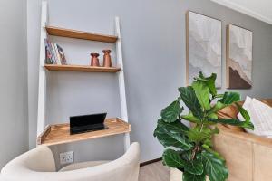 a living room with a chair and a plant at Afrikaya Luxurious Apartment in Roodepoort