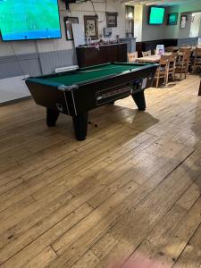 a pool table sitting on top of a wooden floor at The Staging Post in Aberdeen