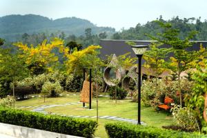 a garden with a large sign in the grass at Monkeys Canopy Resort in Kajang