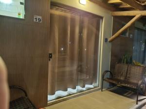 a balcony with a sliding glass door with a bench at Aconchego da Jandaia in Imbassai +33 photos