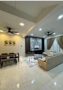 a living room with a couch and a table at NAFIZ Pool Homestay Melaka - Fully AC 4 Rooms with 3 Toilets, PS4 in Kampong Alor