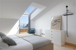 a bedroom with two beds and a chair at ATeRIAN GAZTETAPE II in Getaria