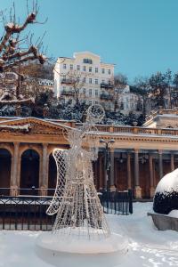 a sculpture in the snow in front of a building at Hotel Ontario in Karlovy Vary +103 photos