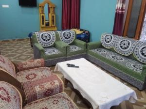 a living room with a couch and a table and chairs at Green Valley Homestay in Barkot