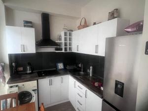 a kitchen with white cabinets and a stainless steel refrigerator at Tini's Apartment in Gonio