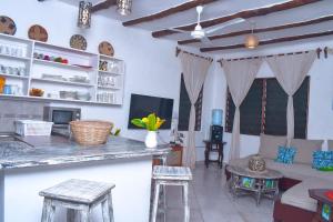 a kitchen and living room with a counter and stools at Horizon Bavaria Villa in Mtwapa
