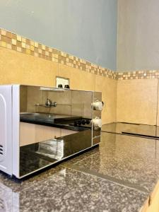 a kitchen with a toaster oven sitting on a counter at Palmetto guesthouse in Mahikeng