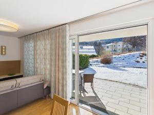 a living room with a sliding glass door to a patio at LakeSide Suite in Seeboden