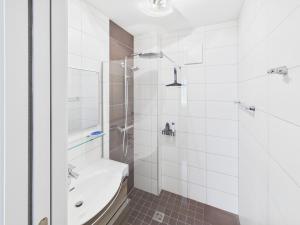 a white bathroom with a shower and a sink at LakeSide Suite in Seeboden +13 photos
