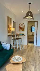a living room with a green couch and a table at Casa Alba in Saint-Chamond