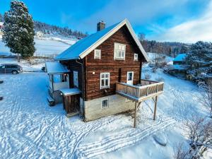 a small wooden house in the snow with a car at Leave It All in Venabygd