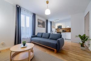 a living room with a blue couch and a table at Disney 12 min - Gare 5min à pied - Self check-in in Esbly +13 photos