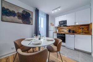 a kitchen with a table and chairs in a room at Disney 12 min - Gare 5min à pied - Self check-in in Esbly