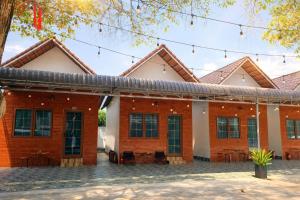 a red brick building with black windows at Lê Thuận Hotel in Lai Vung