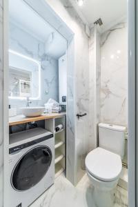 a white bathroom with a toilet and a sink at Disney 12 min - Gare 5min à pied - Self check-in in Esbly