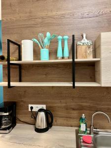 a kitchen counter with shelves with vases and a sink at Nieznany Bór 8 in Hajnówka