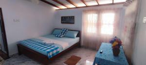 a small bedroom with a bed and a window at HindaHaven in Weligama