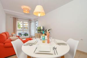 a dining room with a white table and a red couch at Apartment Happy Coast Moraira in Moraira
