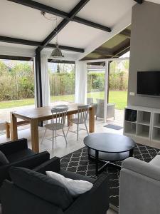 a living room with a table and a dining room at Spacious 6p vacation home with garden in Zoutelande