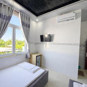 a small bedroom with a bed and a window at Lê Thuận Hotel in Lai Vung