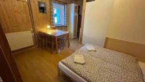 a room with a bed and a table and a dining room at Chalupa Lázeňka in Pernink
