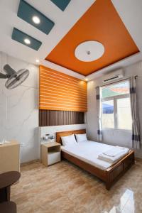 a bedroom with a large bed with an orange ceiling at Lê Thuận Hotel in Lai Vung