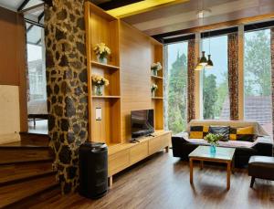 a living room with a couch and a tv at 5BR Villa with Private Pool Lembang in Bandung