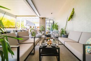 a living room with couches and tables and plants at Hotel Crystal in Orebić