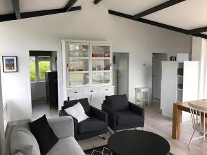 a living room with a couch and chairs and a table at Spacious 6p vacation home with garden in Zoutelande +5 photos