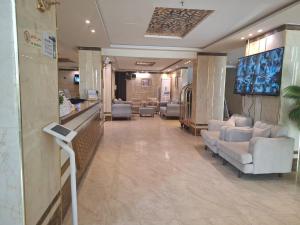 a lobby with a waiting room with couches and chairs at ابراج الجود للشقق المخدومة in Al Ḩawīyah