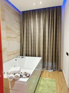 a bathroom with a white tub and a curtain at Aurelis Hotel in Bërxull +25 photos