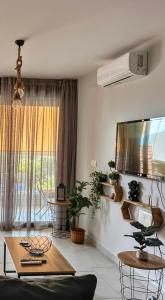 a living room with a table and a large window at EXOTIC LUXURY APARTMENT in Nikiana