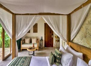 a bedroom with a tent with a bed and a couch at ARYA Sumba - Kodi Resort in Tambolaka +80 photos