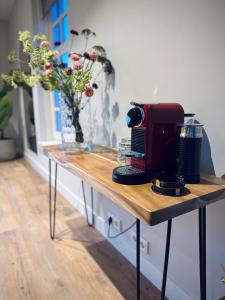 a table with a coffee maker and flowers on it at Het Koetshuis in Zwolle