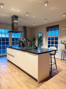 a kitchen with a large island with a black counter top at Het Koetshuis in Zwolle
