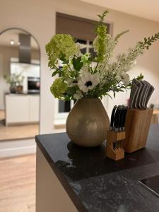 a vase with flowers on a counter in a kitchen at Het Koetshuis in Zwolle +24 photos